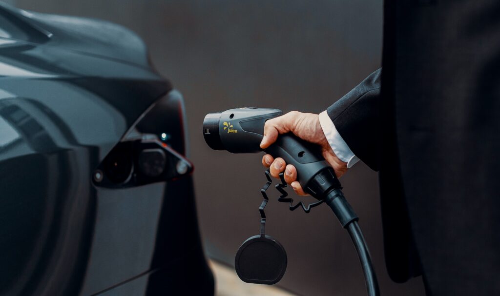 a man in a suit is pumping gas into a car