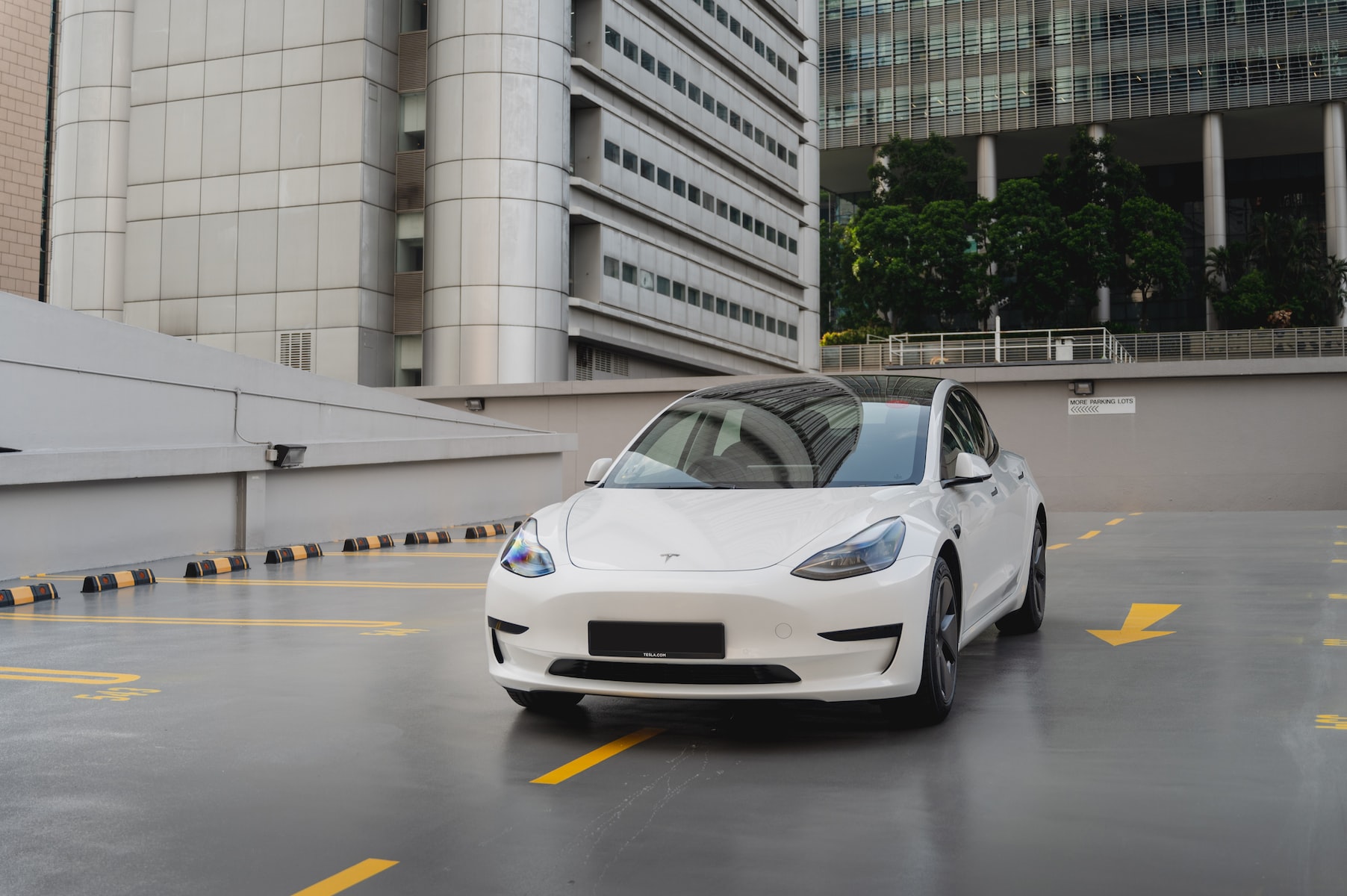 a white car is parked in a parking lot